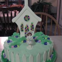 First Communion From the wilton yearbook. Bushes and church are made of colour flow. Flowers are royal icing. Covered in buttercream. Stained glass windows...