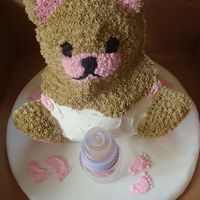 Baby Bear Cake Baby bear cake with baby feet and bottle on cake board.