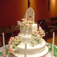 Communion.jpg Bottom tier is lemon, middle is chocolate, top is vanilla. Fondant with buttercream accents. Gum paste flowers (my first!)
