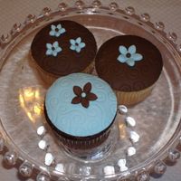 Blue And Brown Cupcakes These were for a bridal shower. Cupcakes were covered in buttercream and topped w/ fondant circles and flowers. Thanks for looking!