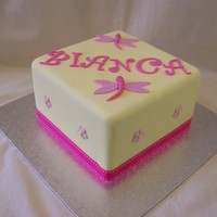Square Lemon And Pink 6 inch mud cake covered in lemon yellow fondx with fabric ribbon.