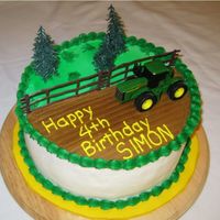 John Deere Tractor Cake 10" round, all buttercream decoration with plastic cake toppers. The child wanted a toy he could play with after he ate the cake!