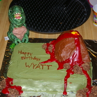 Wyatt's Dino Cake Dinosaur cake iced in buttercream. Volcano made out of RKT & iced in buttercream. Lava made with Wiltons sparkly gel.
