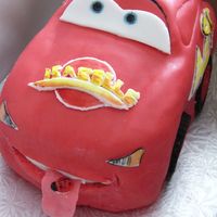 Mcqueen fondant over carved cake, painted details, ladybug on tongue as requested by birthday child.