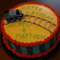 Thomas Train Birthday Cake Birthday cake for my 2 and 4 year old. They loved it. Iced in buttercream with fondant tracks and stripes. Thomas wooden toy.