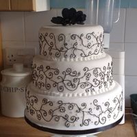 Black &white Scroll Cake 3 tier dummy for an exhibition. White fondant decorated with free hand black scrolls and trimmed with diamante. The topper is black...