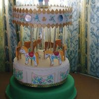 Carousel Wedding Cake designed for my sister who met her partner while working at a theme park. The horses are NFSC cookies and to top it there is a very thin...