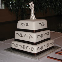 Square Cake With Brown Accents This is a white cake with raspberry filling covered in fondant. The scrolls are hand painted. Thanks for looking!