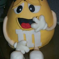 Yellow M&m Guy Cake done with 3-d egg pan. Covered in fondant with fondant accents. Had to put a bee on his head 'cause the skewer came out his head...