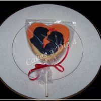 Sunset_Silhouette_Cookie-Cc.jpg Heart shaped sugar cookie pop decorated with Alice Cookie Icing. Depicting a silhouette of a couple embracing at sunset. Overpiped to give...