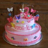 Teddy Bear With Flowers Two tier cake 6" and 10" in buttercream icing, all the flower, butterflies, teddybrear and the number in MMF.