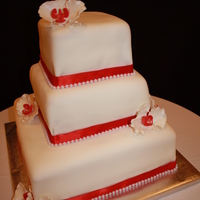 Simple With Orchids Simple wedding cake covered with fondant, real fabric ribbon (which I had a hard time to have it stick to cake) made orchids with gumpaste...