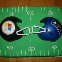 Super Bowl 40 This cake is covered in marshmallow fondant. The helmets were made with the sports ball pan and covered with fondant as well.