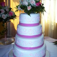 My First Wedding Cake This was a four-tier cake covered in fondant. The ribbon was made of fondant and the scrolls piped with royal icing and tinted to match the...