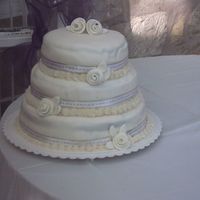 My First Wedding Cake! Choc. cake with choc filling covered in buttercream then fondant with white and gold ribbon. Roses and leaves are fondant. Brought it over...