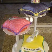 Three Princess Pillows MY FIRST ATTEMPT AT DOING PILLOWS - NOT AS HARD AS I THOUGHT BUT STILL TIME CONSUMING. THE SHOE, WAND AND CROWN ARE ALL GUMPASTE.