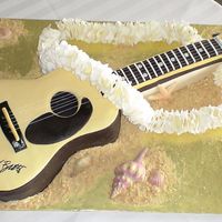 Jimmy Buffett Guitar Cake board is 20" x 30" and the entire guitar is cake/fondant with the exception of the silver metallic embroidery thread strings...