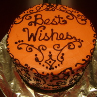 Best Wishes This is a 4 layer vanilla cake with tangerine-colored buttercream and chocolate swirl designs.
