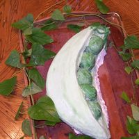 Peas In A Pod I took a 12" round cake and cut in Half then shaped each half into a crescent moon shape . I trimmed out center while cake was frozen...