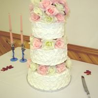 Pink And White Roses 3 tier 8-10-12 white cake with strawbewrry mousse filling. BC icing with silk flowers as requested by the bride.