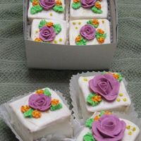 Mini Flower Cakes white modified cake with wedding bouquet flavor added. torted half a sheet cake and filled with rasberry filling then cut into 2X2 squares...