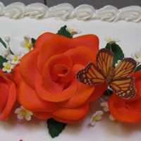 Coral Roses gumpaste roses, leaves, and white filler flowers. airbrushed the roses with an orange and pink color that i made. then i dusted the inside...