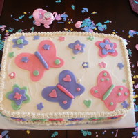 Shower Cake For Ava Fondant butterflies and flowers on a buttercream field.