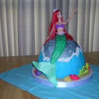 Mermaid Barbie's fish tail is made of gumpaste and fondant, making it appear that she sits on the cake. She is actually stuck into the center...