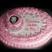 Princess Chloe Sour Cream Almond White cake in large oval, 4" mini-cake inside crown, Buttercream icing, and fondant flowers and hearts. Sugar...