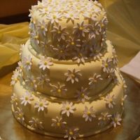Tinas_Cake.jpg Three tiered cake covered in fondant. Fondant daisies. I made this cake for my cousins baby shower. She got the idea from Martha Stewart&#...