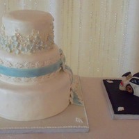 Wedding Cake With Lace Floral Side Design And Groom Car Cake Main Wedding cake with grooms car cake. Car cake was really rice krispy treats because it was way too small to make effort carve it out of cake...