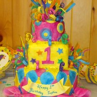 Whimsical Mardi Gras Themed Birthday Cake For First Birthday this Mardi Gras cake has 7 different colors to match child's birthday outfit. All streamers, bows, stars, ribbons are edible gumpaste...