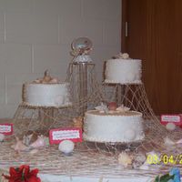 Amber And Jay Sea shell them, fish net layed over my stand. Shells and net provided by the bride. Shells were from the bride and grooms wedding in Jamica...