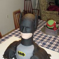 Batman Huge amount of chocolate cake with choc frosting all covered in fondant. Head is a male wig head also covered in fondant so it also serves...
