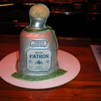 Patron Tequilla stacked cakes, shaped bottle base, used circles to cut and stack the neck of the bottle, then rolled icing and graham cracker grumbs...