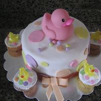 Polka Dot Ducky Cake First fondant cake for 1 year old birthday. Rubber ducky on top. BC cupcakes with duck candles on top.