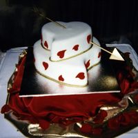 Cake2Jpg.jpg This is another polystyrene wedding cake for another niece. The white and red are fondant. The arrow is a wooden skewer with a cardboard...