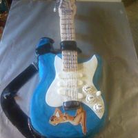 Fender Strat Guitar This was a replica of a fender strat guitar. Base is cake and neck is rice krispie treats. Decorated all with fondant except guitar strings...