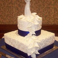 Calalilies And Buttercream calalillies made of fondant, buttercream cakes with swirls and satin ribbon.