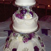 Wilton Design With Fresh Flowers tiered buttercream cake with fondant arches around bases.