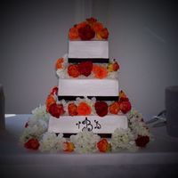 Danielle's Cake This is a three tiered square cake. It is iced in BC with brown ribbon around the bottom of each tier. The flowers are real roses and silk...