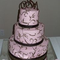 Pink & Brown Wedding Cake A 3 tiered french vanilla cake with strawberry filling. Iced with pink buttercream, decorated in brown buttercream. Accents include brown...