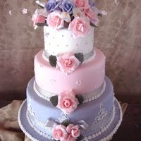Tricolor Fondant Wedding Cake lilac, pink, and white colored fondant with pink and voilet colored roses further adorned with calla lilies and small wired flowers
