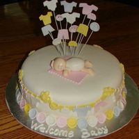 Cute As A Button! MMF covered 10" cake with handmade sculpted baby. Fondant babyclothes on 20 gauge wire. Handmade buttons. Thanks for the great ideas...