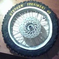 Motocross Bike Tire 16" tire, fondant covered. Front brake (the silver circle in the middle) is fondant, and spokes are painted cookie/lollipop sticks.