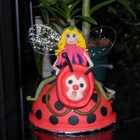 Ladybug Fairy Ladybug body made with 1/2 ball pan covered with fondant. Fairy and Ladybug head made with gumpaste. Wings made with gelatin.