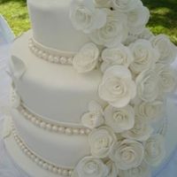 White Wedding Cake Three tiered wedding cake, covered in fondant. Roses and pearls are handmade from fondant and dusted with pearl luster dust. Imade this for...
