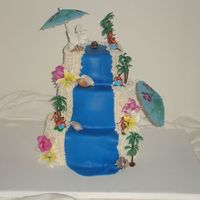 Laua Cake This was a fun cake to make with a fondant waterfall and white buttercream beach. Gumpaste flowers and plastic hawaiian hula dancers and...