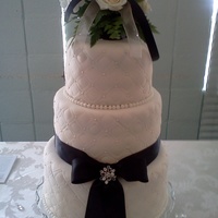 Diamonds And Pearls 3 tier white cake with vanilla mousse. Covered in white chocolate ganache and Wilton white fondant. Hand drawn 1" grid pattern with 1/...