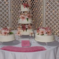 Lily Wedding Cake This cake is covered in fondant with edible pearls for the bottom border. The flowers on top are silk (provided by the bride). I was handed...